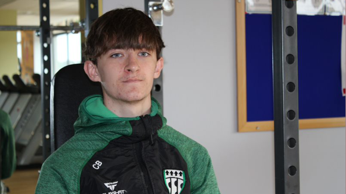 A young male wearing a sports hoodie in a fitness suite